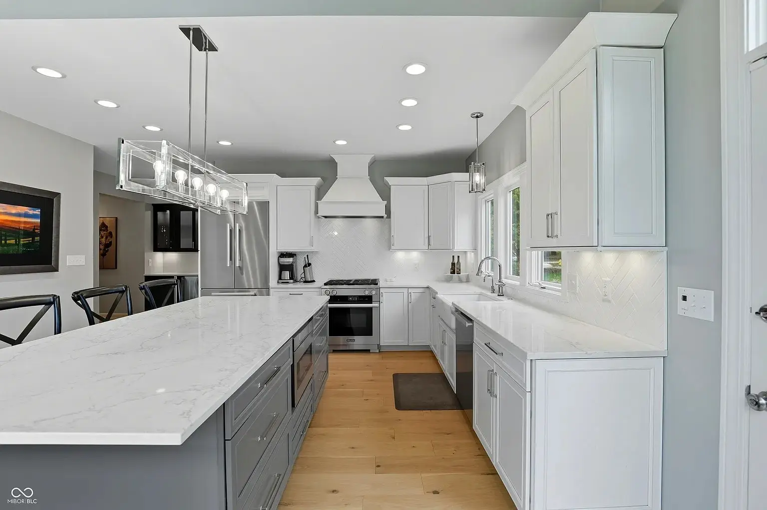 Modern kitchen with white cabinets, stainless steel appliances, and a large marble island countertop.