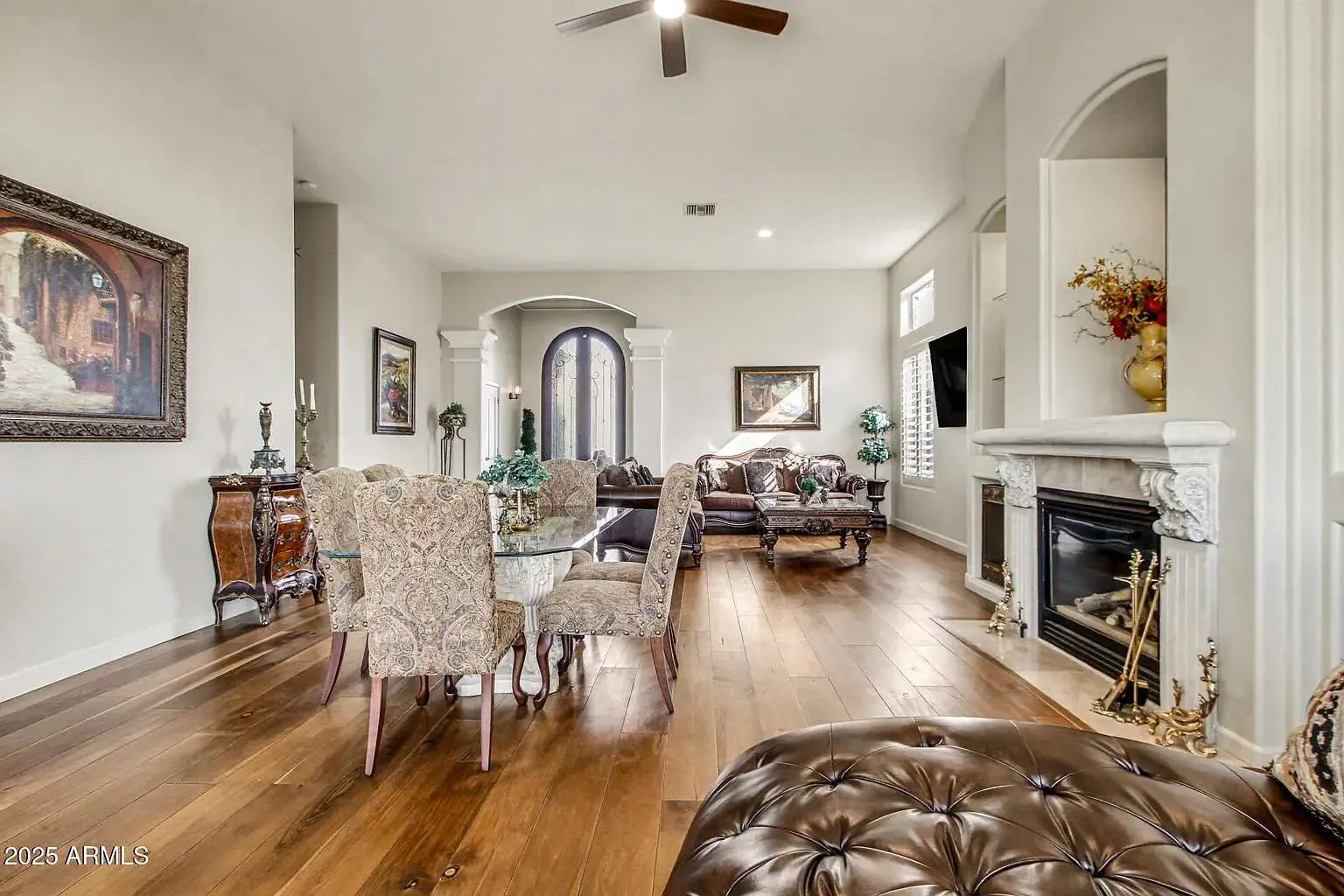Spacious living room with elegant furniture, wooden floor, fireplace, and decorative artwork.