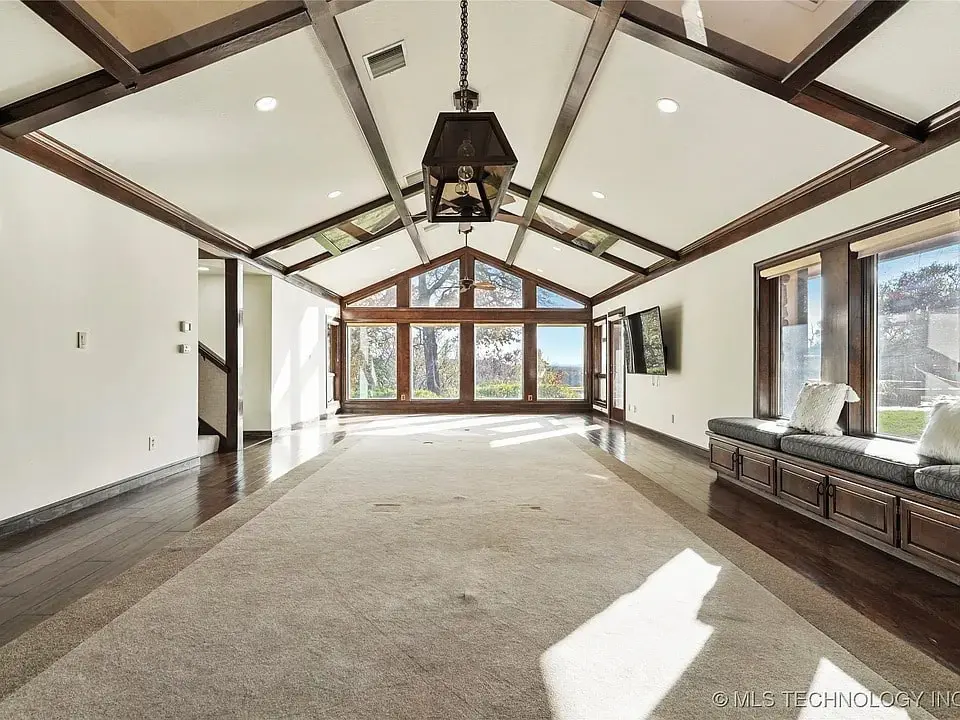 Spacious room with vaulted ceiling, large windows, and built-in window seat.