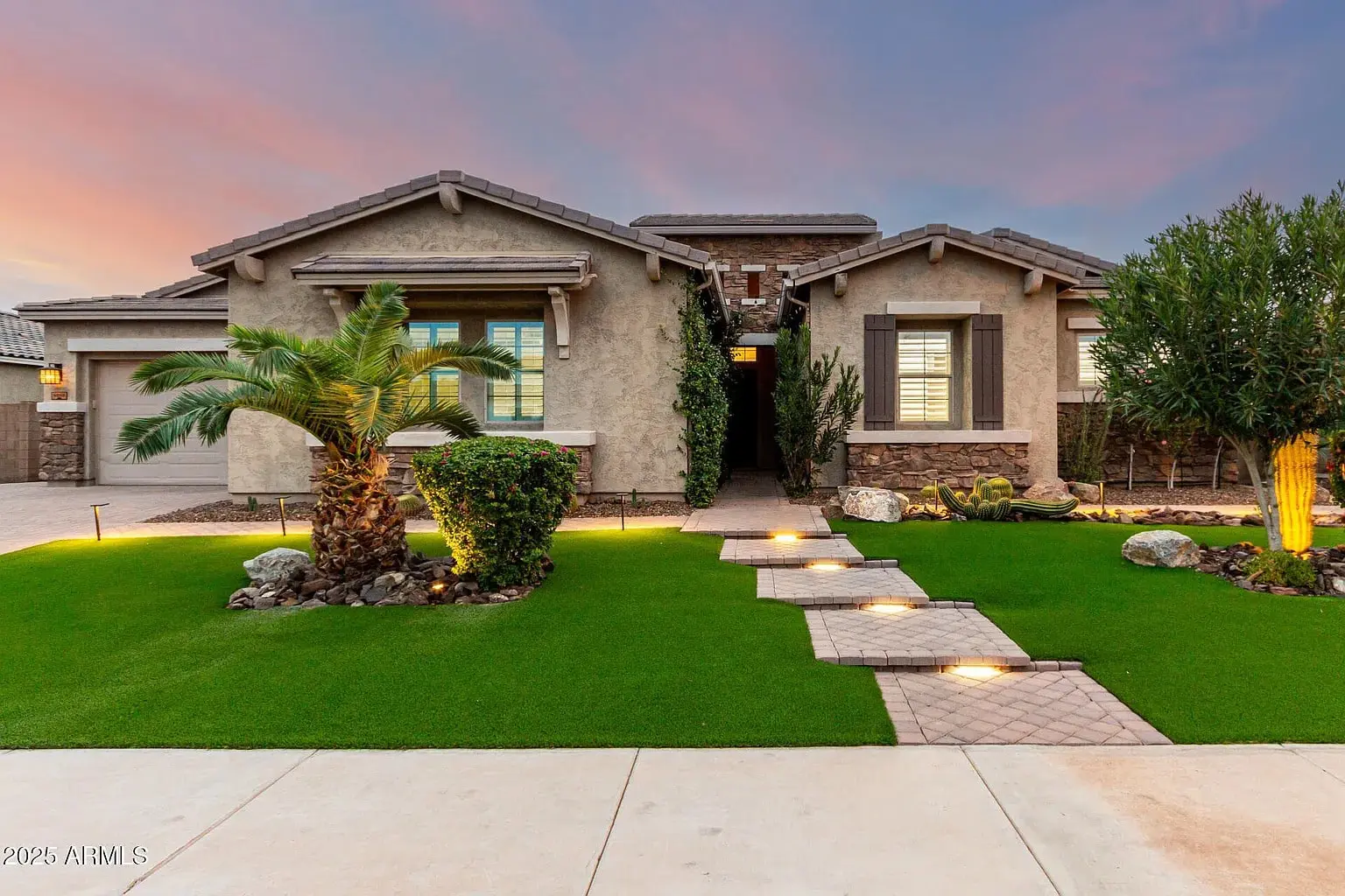 Single-story house with a manicured lawn, palm tree, and stone pathway at sunset.