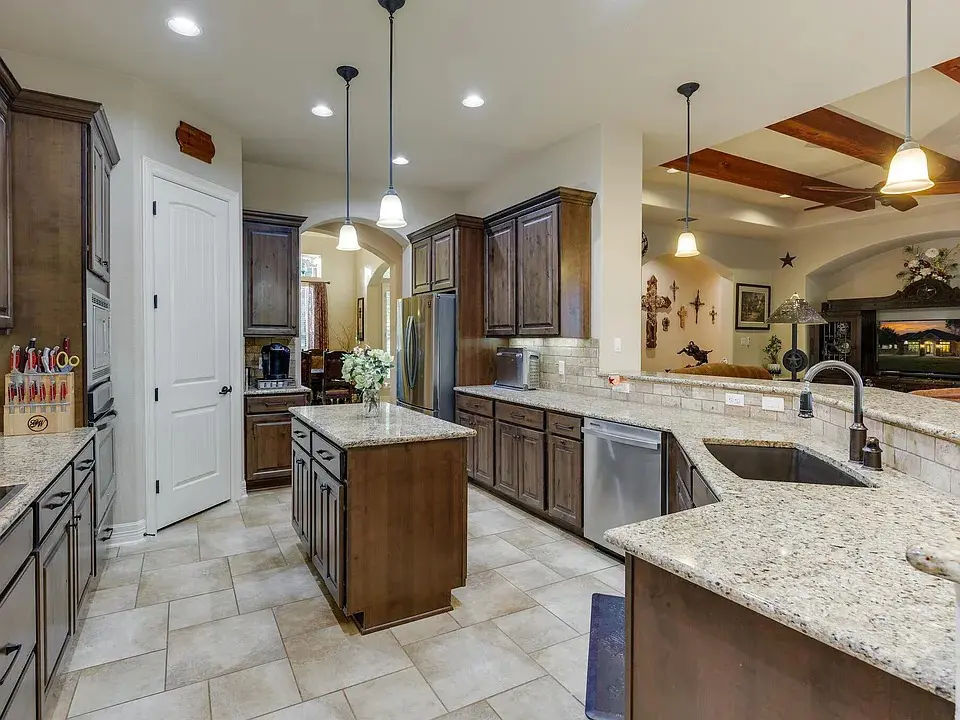 Spacious kitchen with wooden cabinets, granite countertops, and stainless steel appliances.