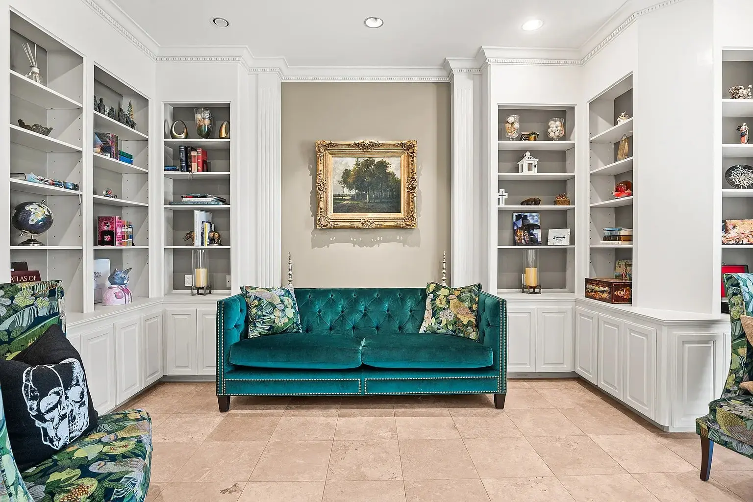 Room with teal sofa, patterned chairs, bookshelves, and a landscape painting on the wall.