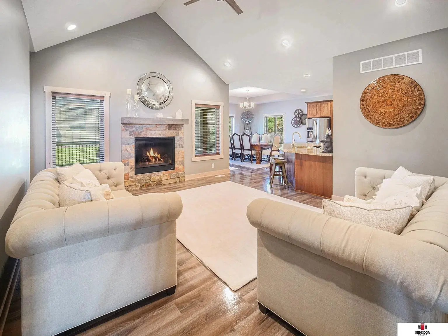 Living room with two sofas, fireplace, and view into dining and kitchen area.