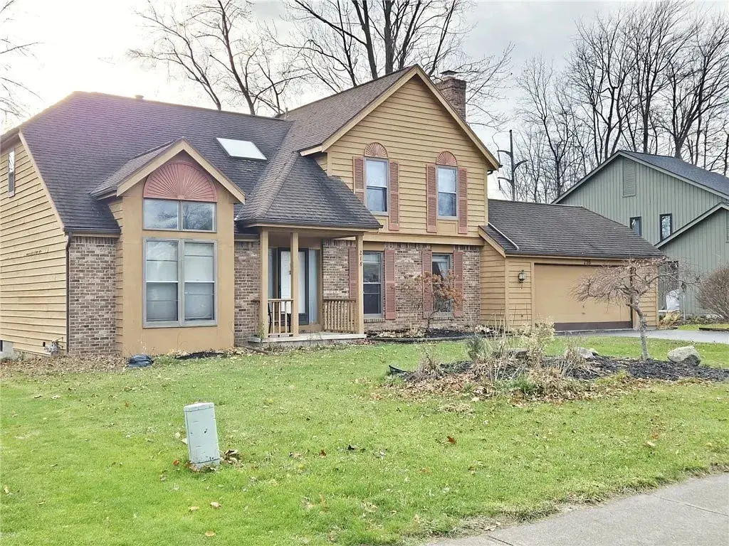 Two-story suburban house with brown siding, brick accents, and a front lawn.