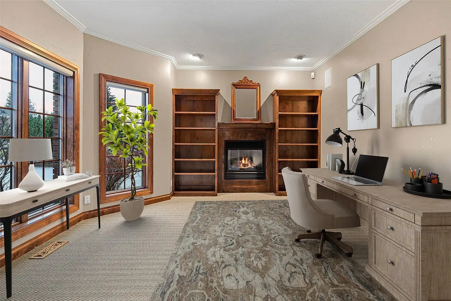 Home office with a fireplace, bookshelves, desk, chair, and large windows with a view.