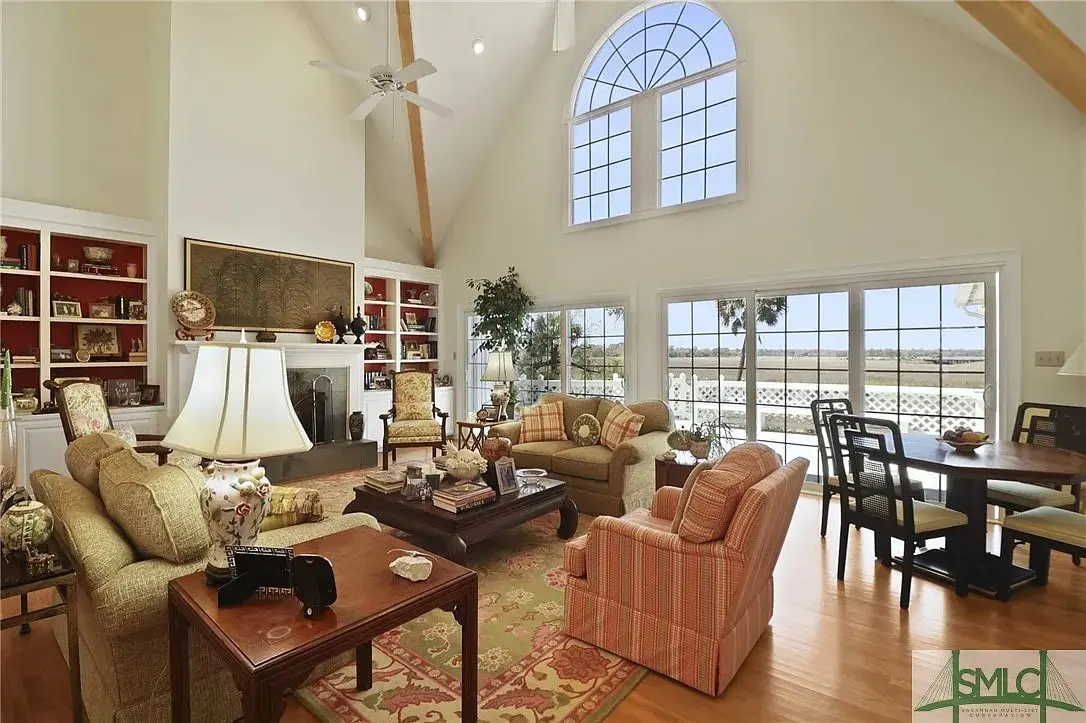 Spacious living room with high ceilings, large windows, and comfortable seating overlooking a scenic view.