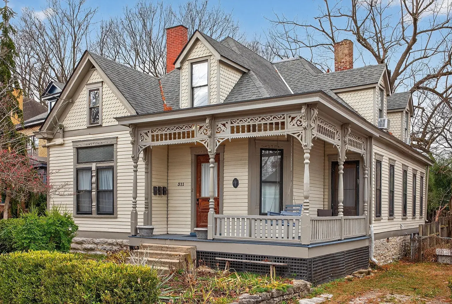 Victorian-style house with ornate wooden trim, gabled roof, and a small front porch.