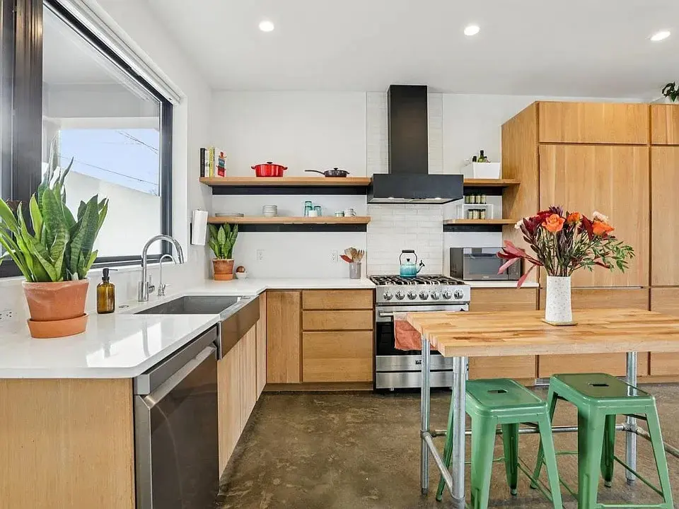Modern kitchen with wooden cabinets, stainless steel appliances, and a center island with flowers.