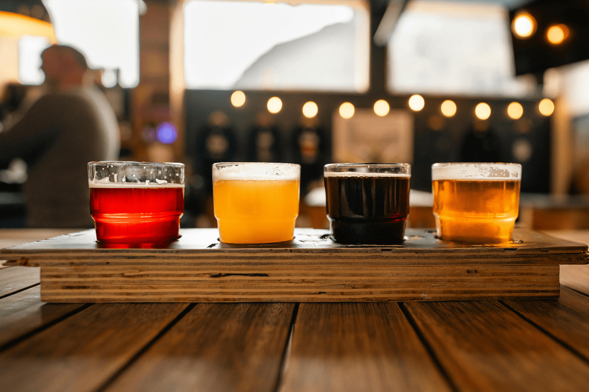 A beer flight sitting on a picnic table.