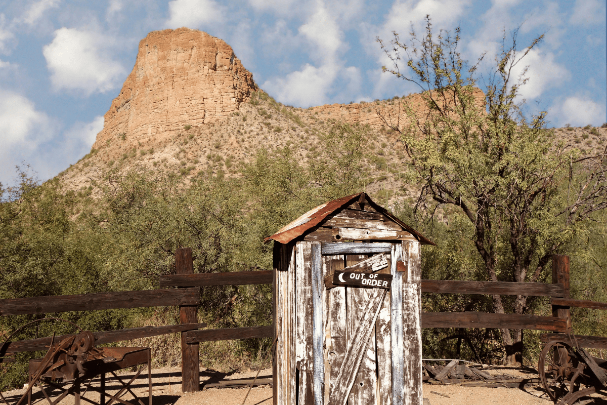 An old abandoned building in the Arizona desert with a sign that says Out of Order.