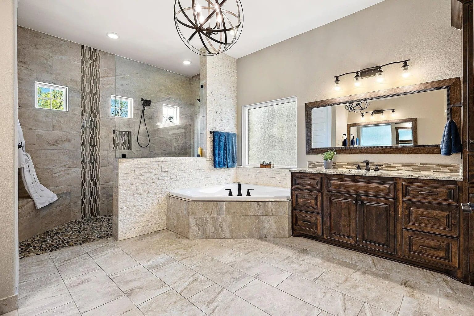 Spacious modern bathroom with a large shower, bathtub, wooden vanity, and decorative lighting.