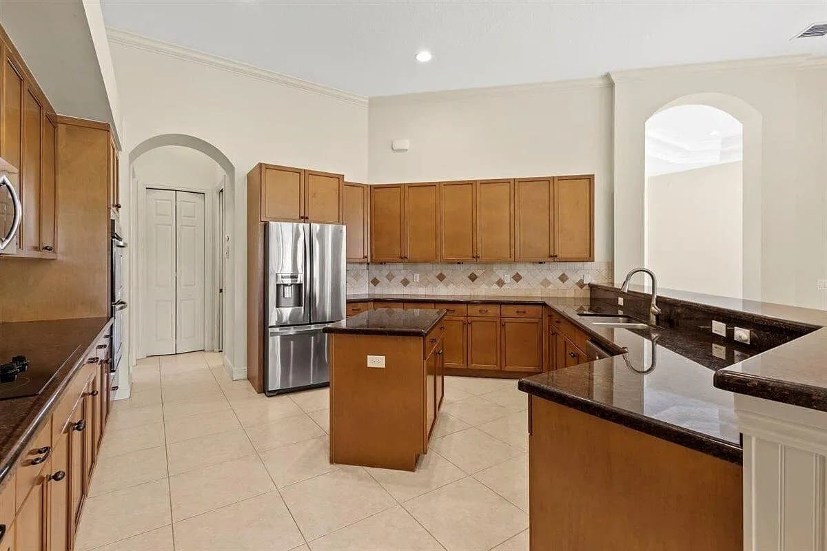 Spacious kitchen with wooden cabinets, stainless steel appliances, and a central island.
