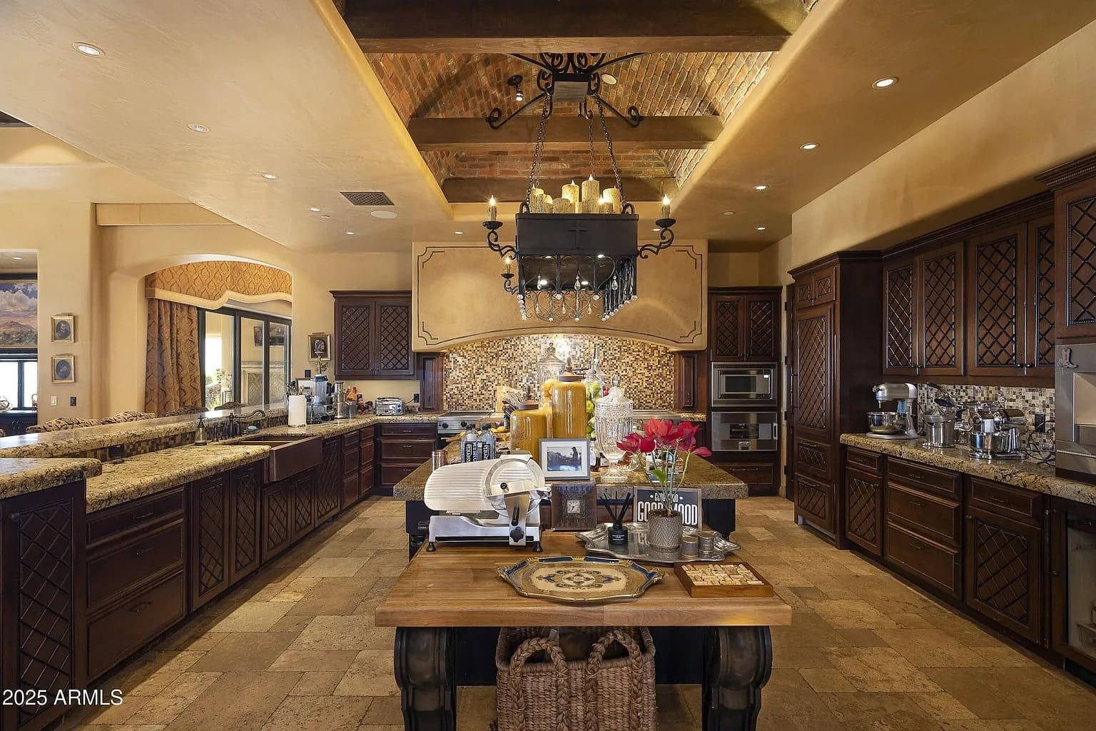 Luxurious kitchen with dark wood cabinets, stone countertops, and a central island with decorative items.