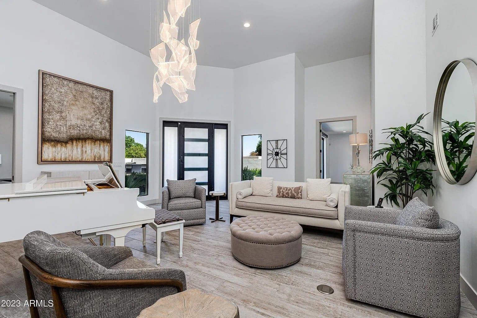 Modern living room with a white piano, abstract art, and contemporary furniture.