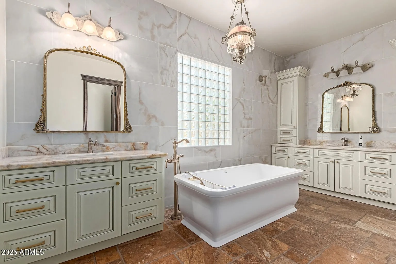 Luxurious bathroom with a freestanding bathtub, dual vanities, and elegant lighting fixtures.
