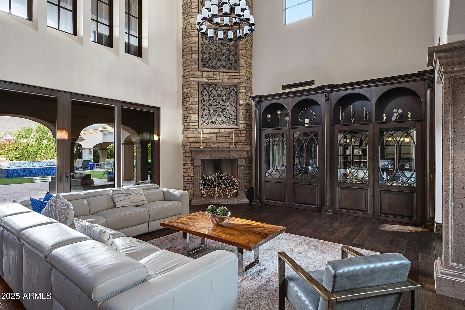 Spacious living room with white sofas, wooden table, fireplace, and large windows.