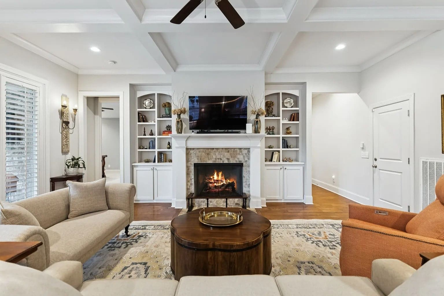 Cozy living room with a fireplace, TV, bookshelves, and comfortable seating.