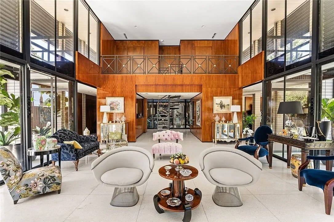 Spacious modern living room with high ceilings, elegant furniture, and large windows.