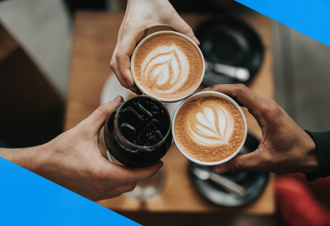 Three hands holding coffee cups with latte art and a glass of iced coffee.