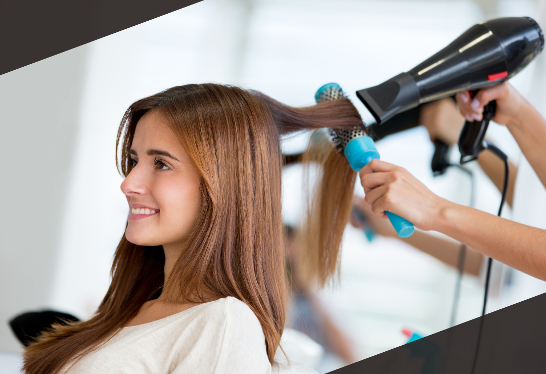 'A woman getting her hair blow-dried at a salon, smiling and relaxed.'