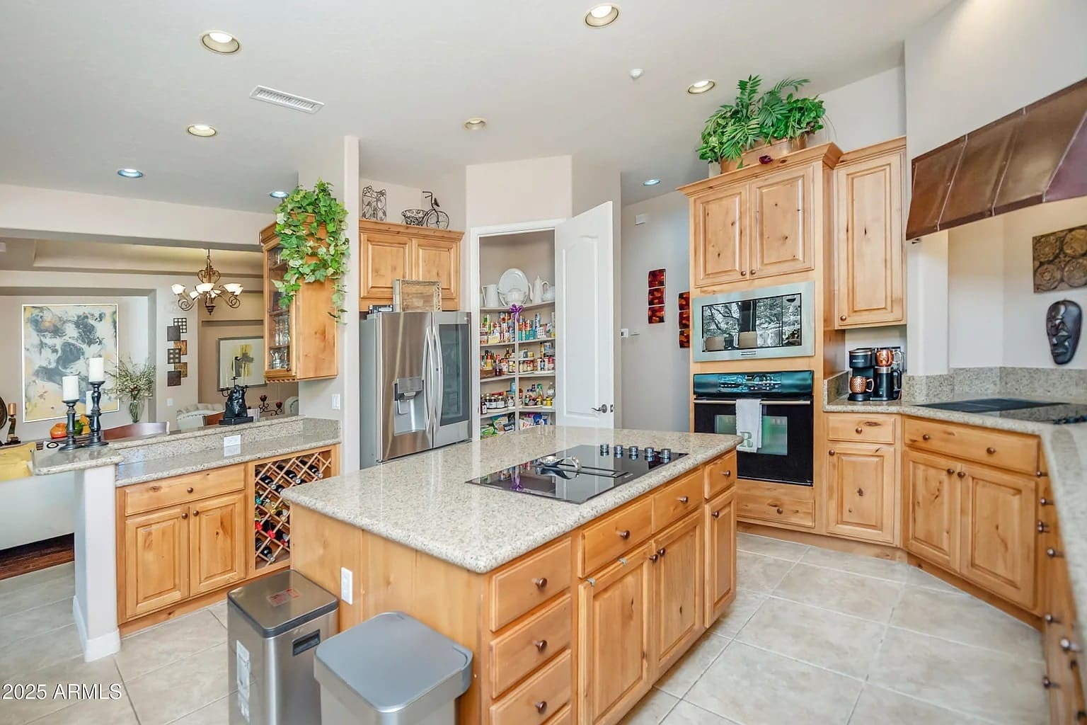 Spacious kitchen with wooden cabinets, granite countertops, stainless steel appliances, and a pantry.