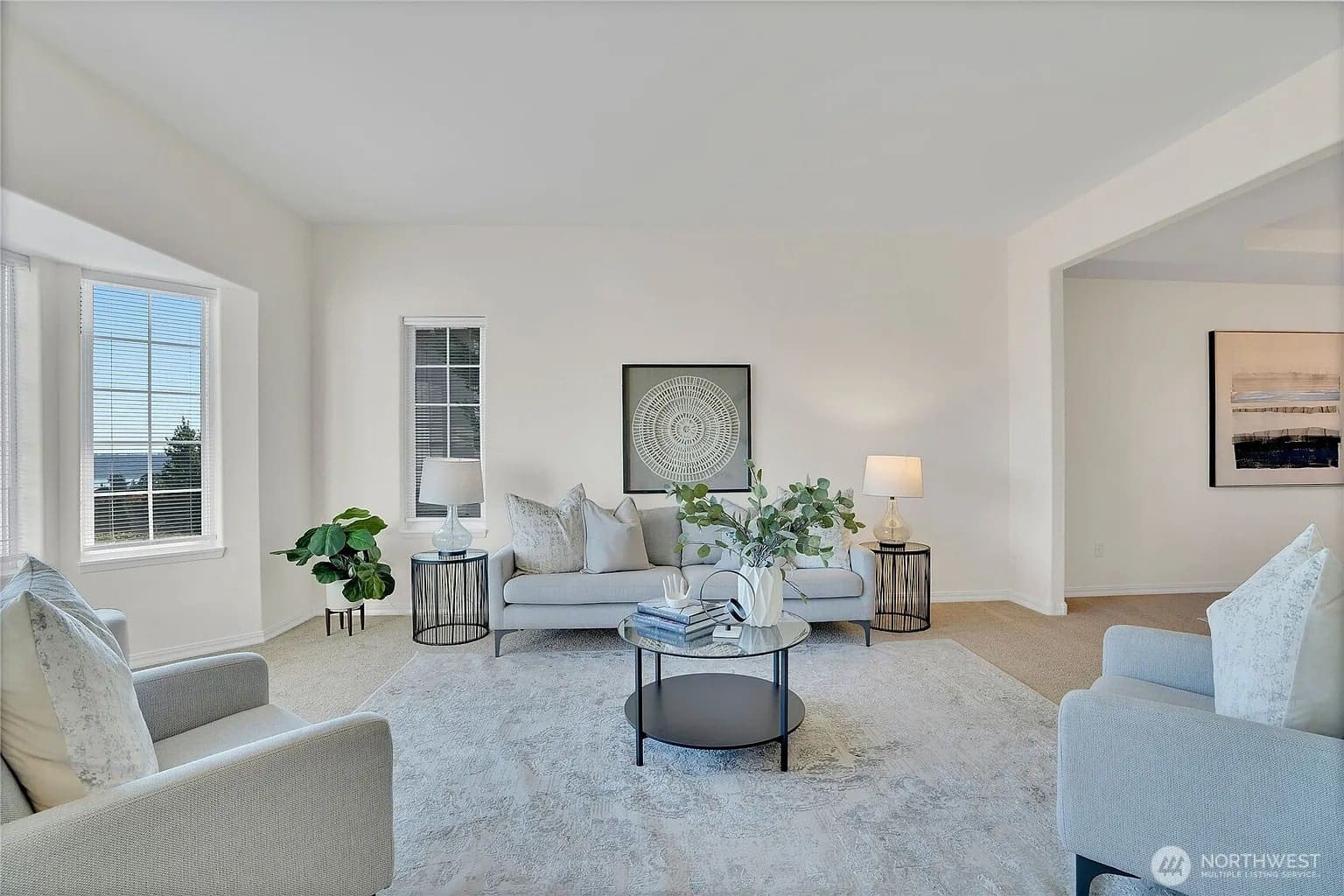Bright living room with modern furniture, large windows, and neutral decor.