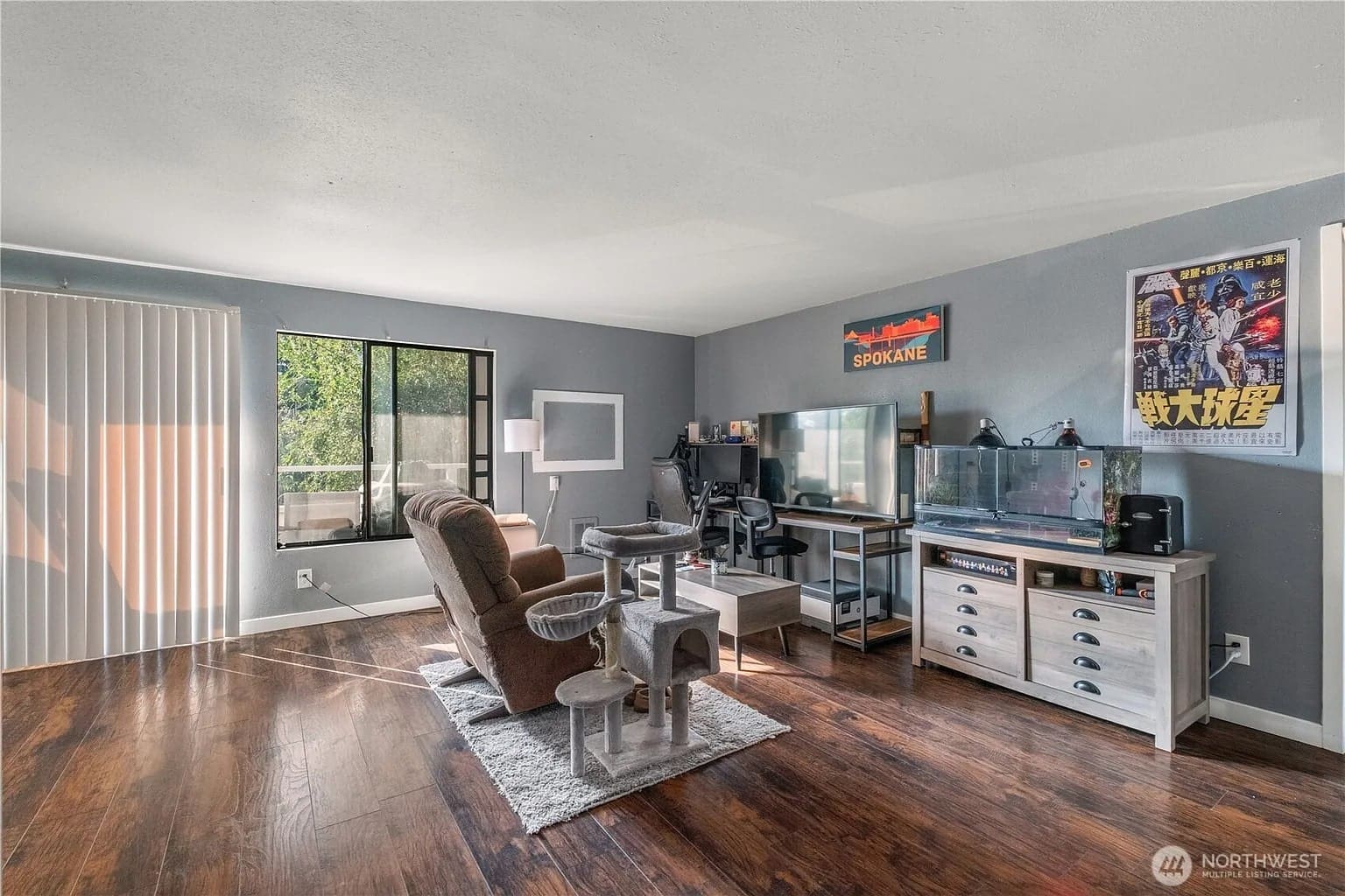 Living room with a desk, computer, armchair, fish tank, and large window.