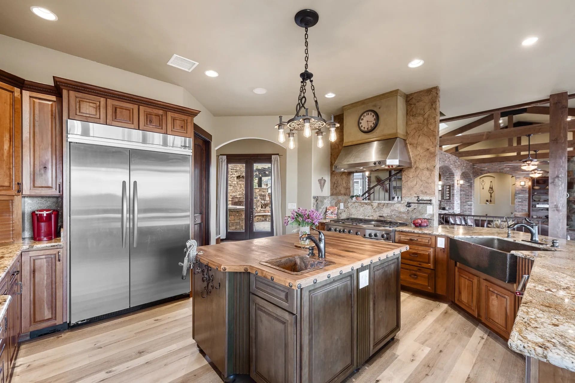 Spacious kitchen with wooden island, stainless steel appliances, and rustic decor.